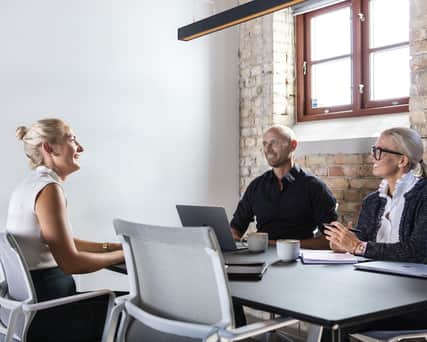 Three people sitting around a table.