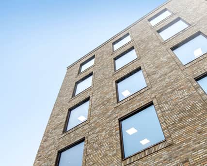 Upwards view of the facade of a brick property.