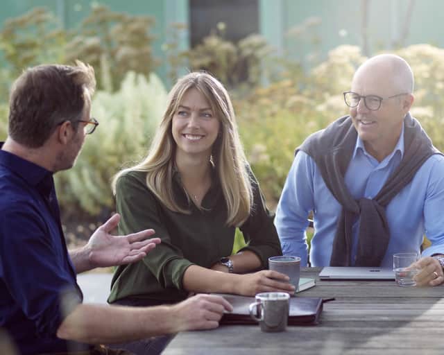 Three people having an outdoor meeting.