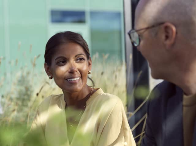 Två personer sitter utomhus och pratar